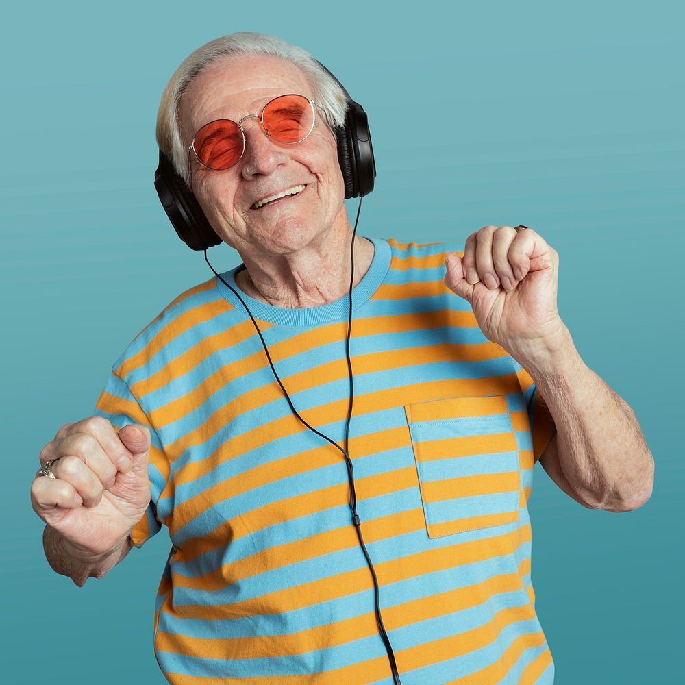 Happy senior man dancing while listening to music with headphones mockup 