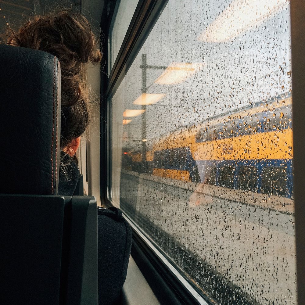 Free woman sitting in train near rainy window image, public domain CC0 photo.