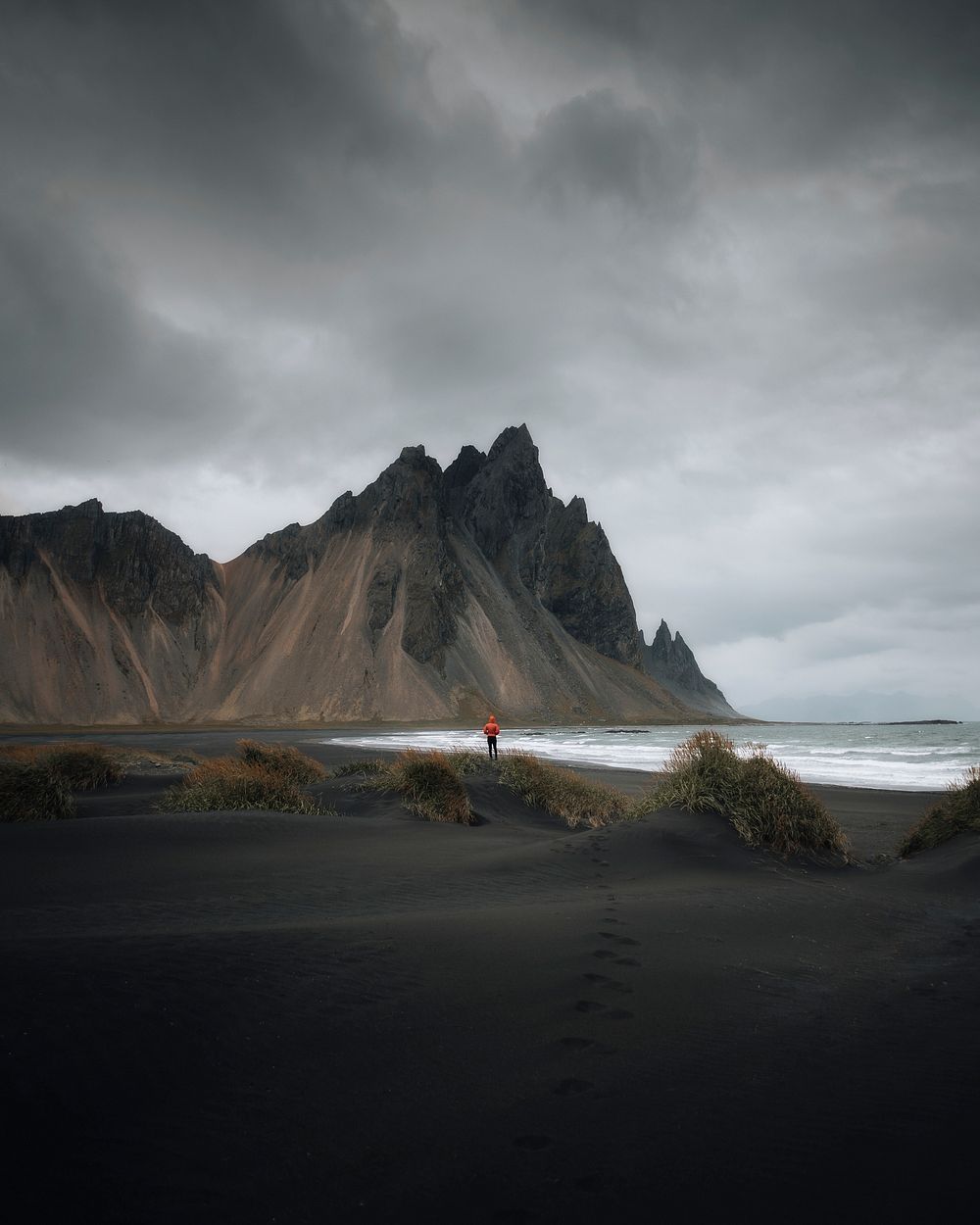 Man walking on a black sand beach, Iceland