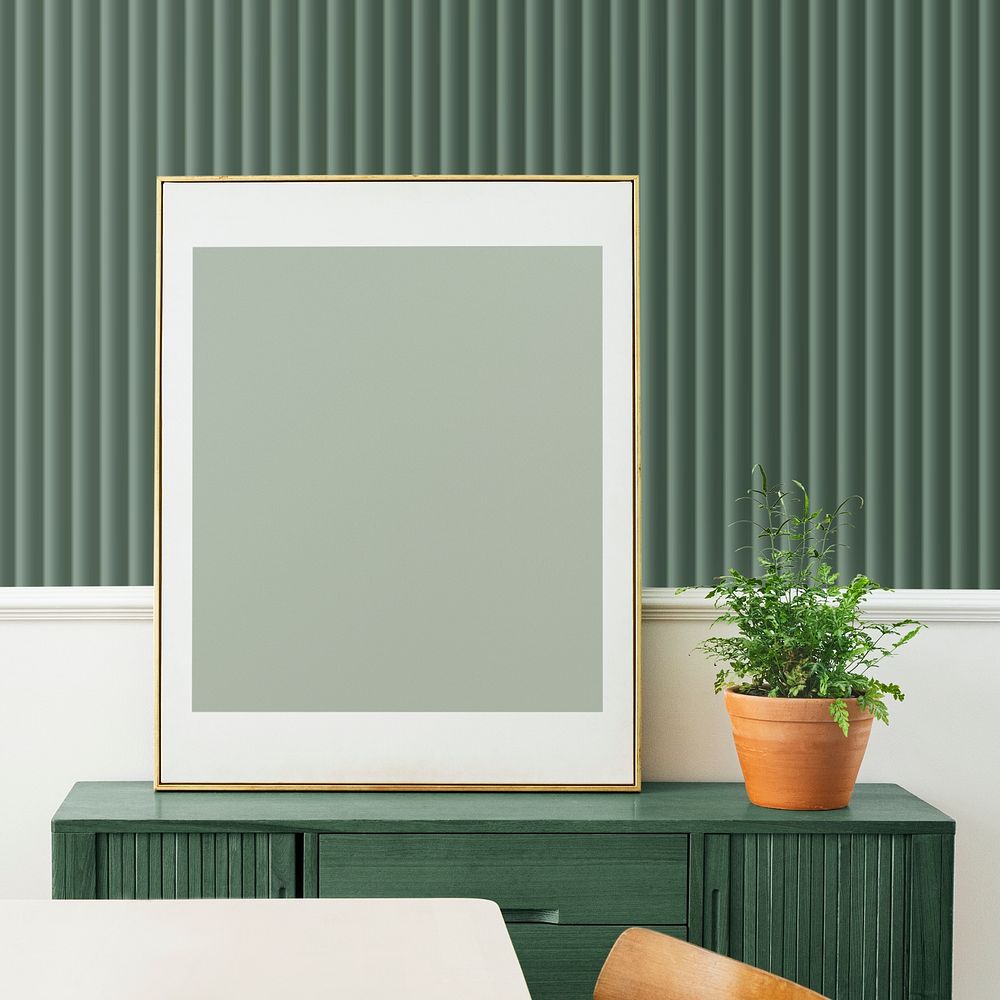 Blank picture frame on a green wooden cabinet