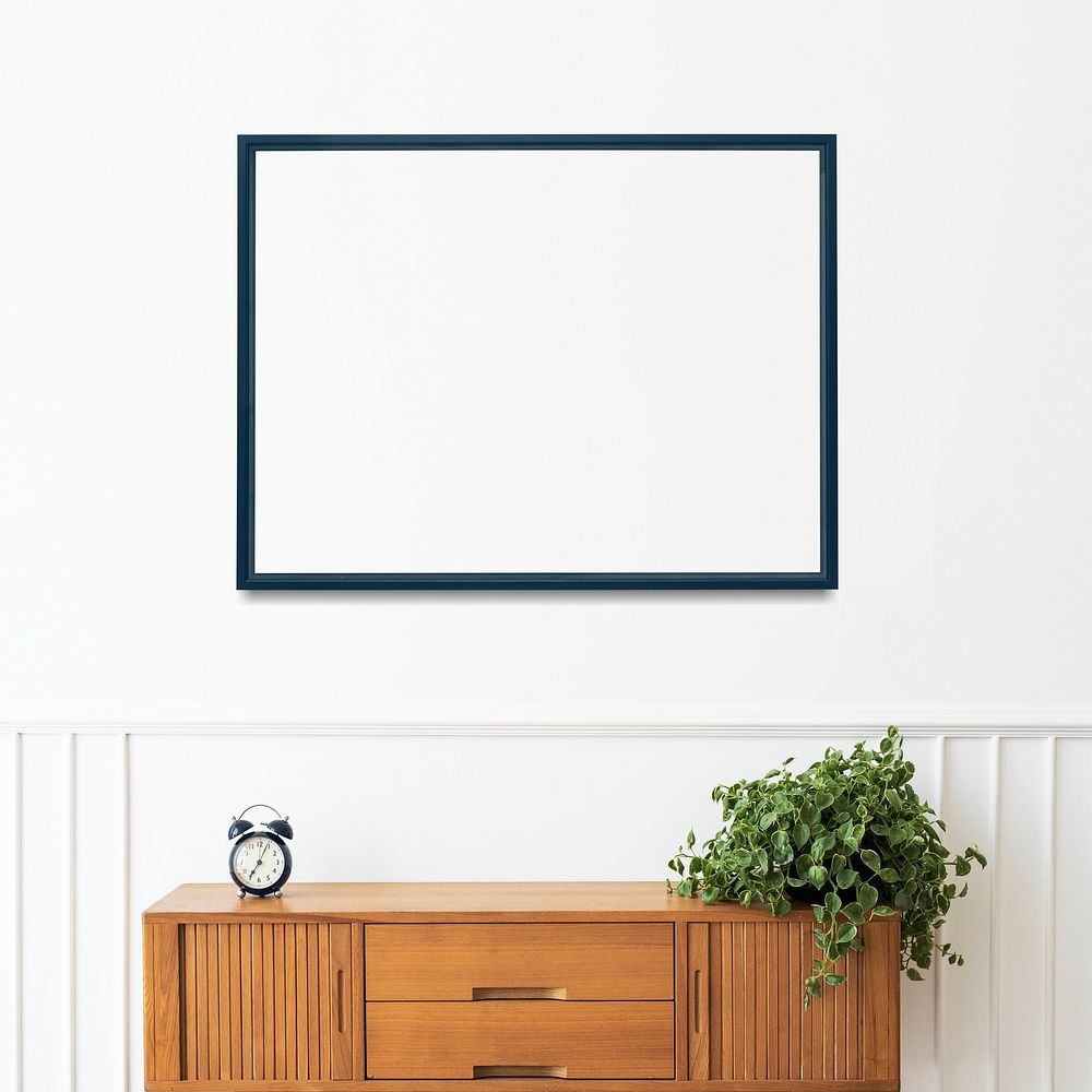 Blank picture frame hanging over the wooden cabinet