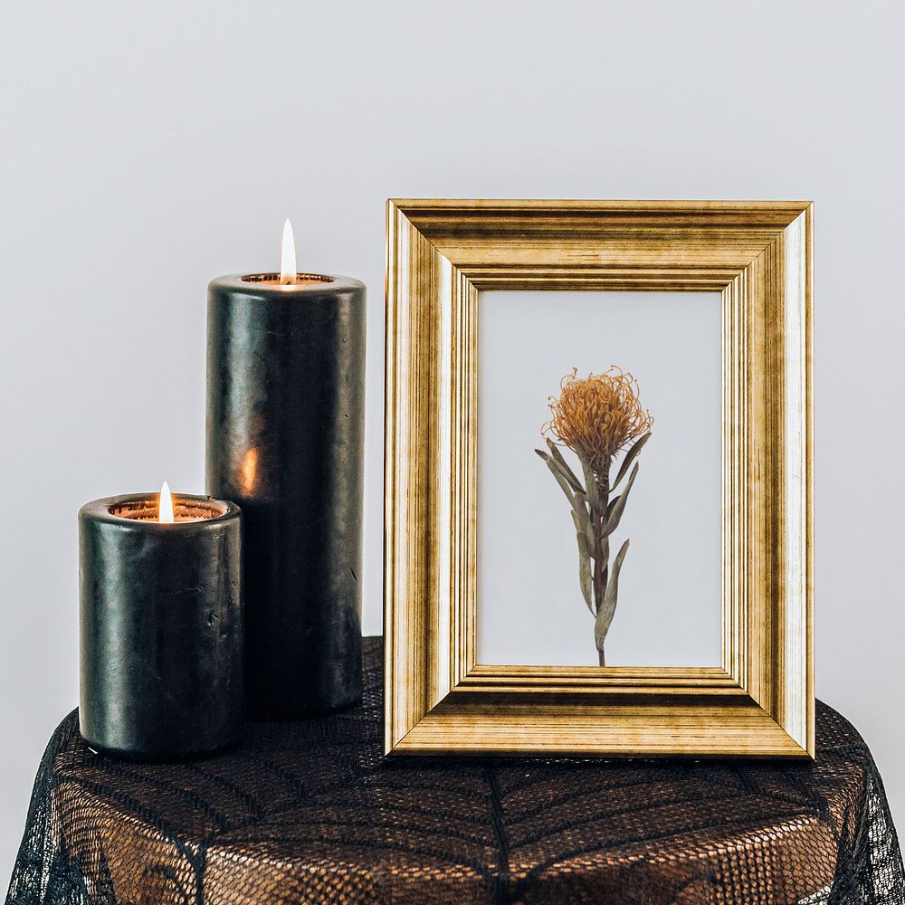 Golden frame mockup by the lighter black pillar candles 