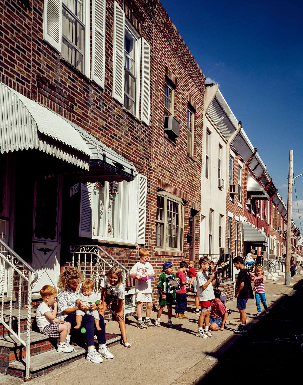 Family time on Daly Street in the Whitman row-house in South Philadelphia, Pennsylvania. Original image from Carol M.…