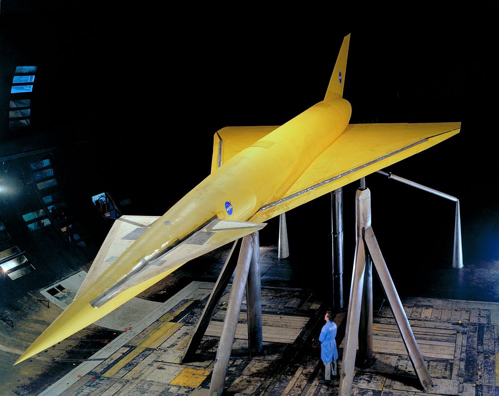 Hypersonic Transport Model. High 3/4 top front view of model in Ames 40x80 foot wind tunnel. Bob Bishop in lower right.…