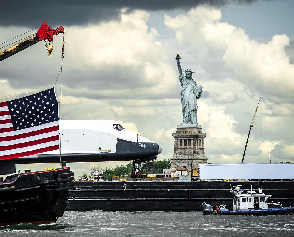 The space shuttle Enterprise, atop a barge, passes the Statue of Liberty in New York. Original from NASA . Digitally…
