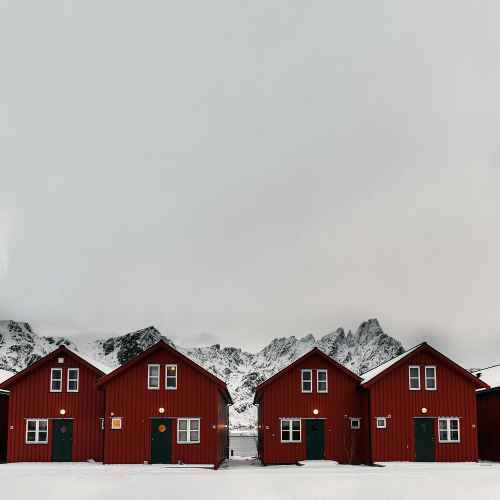 Row of red cabins on a snowy coast of Sakrisoy island, Norway