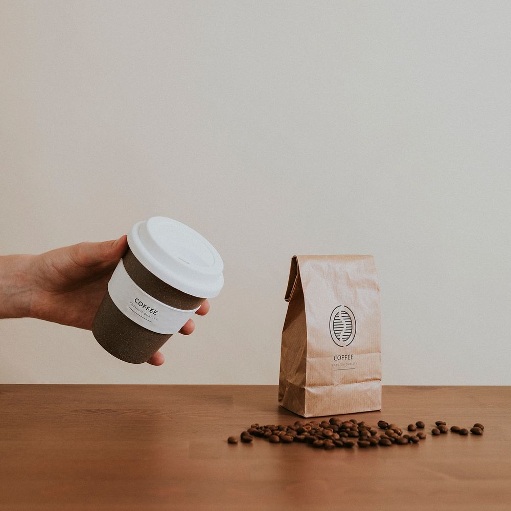 Hand holding a cork reusable cup with coffee beans mockup