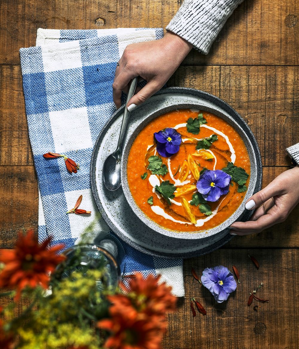 Vegan colorful tomato soup serving on a wooden table