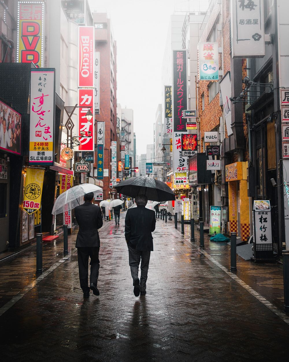 Japanese businessmen walking with umbrellas in Tokyo