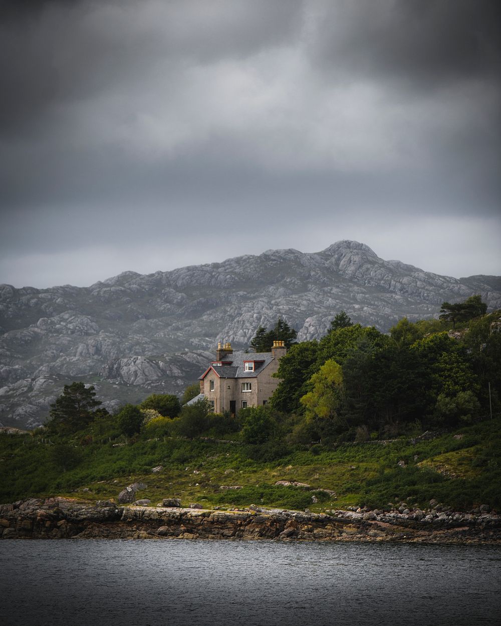 Stone house by the lake on a cloudy day