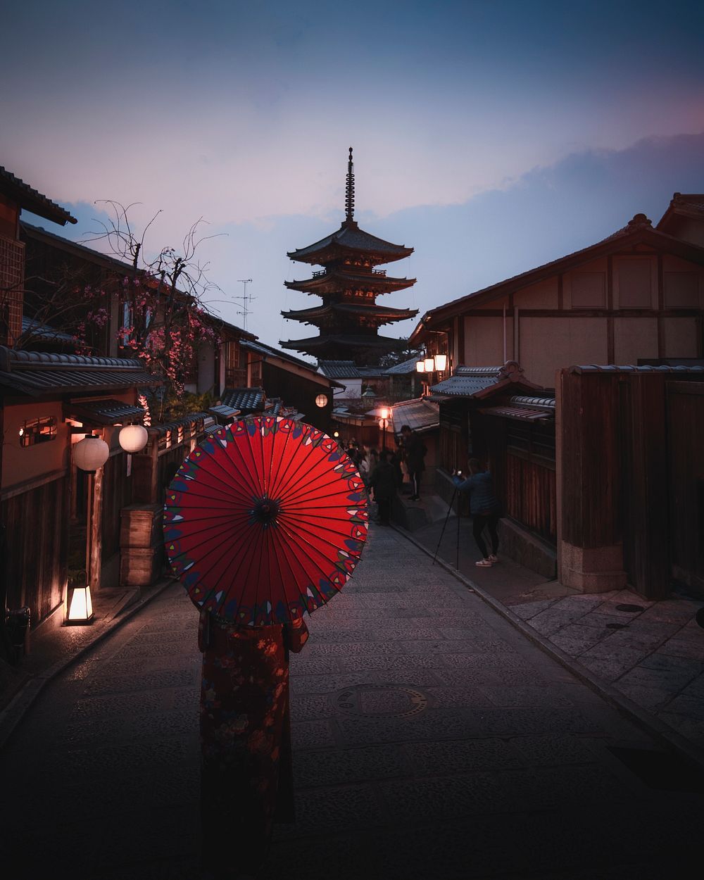 Woman in a kimono walking with a red umbrella at Yasaka Pagoda in Kyoto, Japan