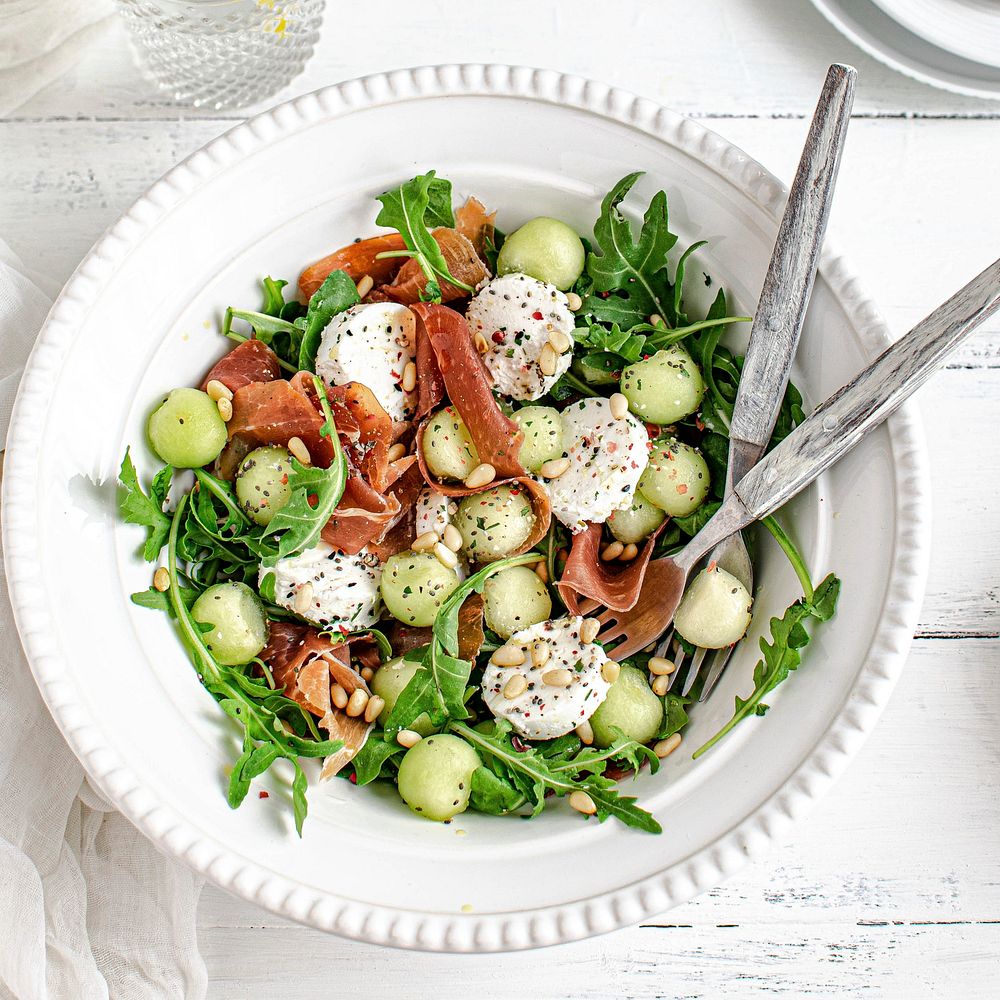 Colorful summer salad bowl with parma ham