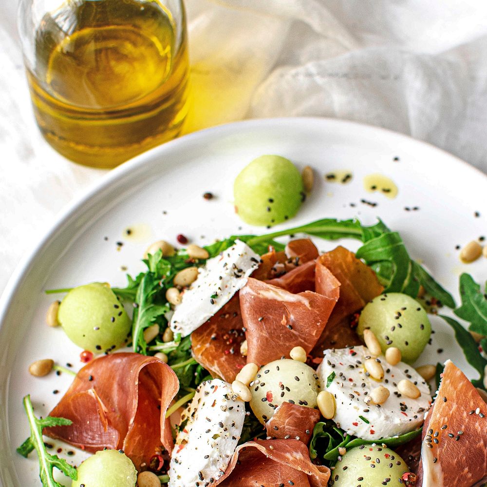 Colorful summer salad bowl with parma ham