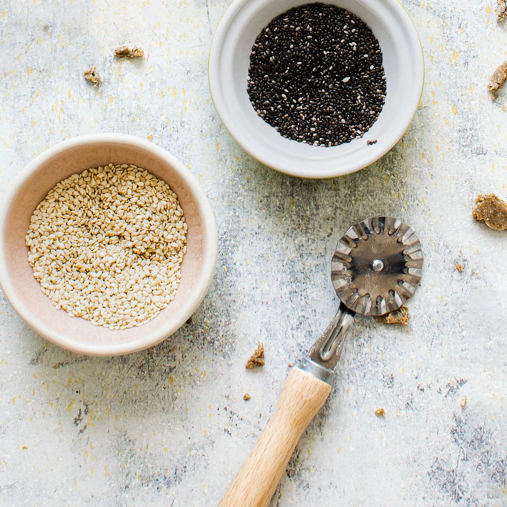 Cups of sesame by a roller knife cutter in a kitchen flatlay