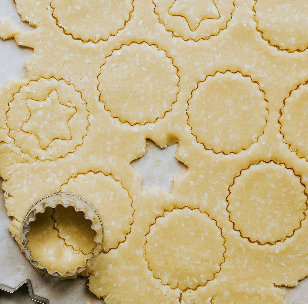 Raw cookies being cut with a star cookie cutter