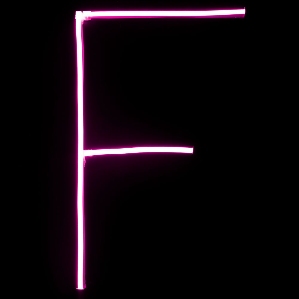 Alphabet pink neon lights on black background