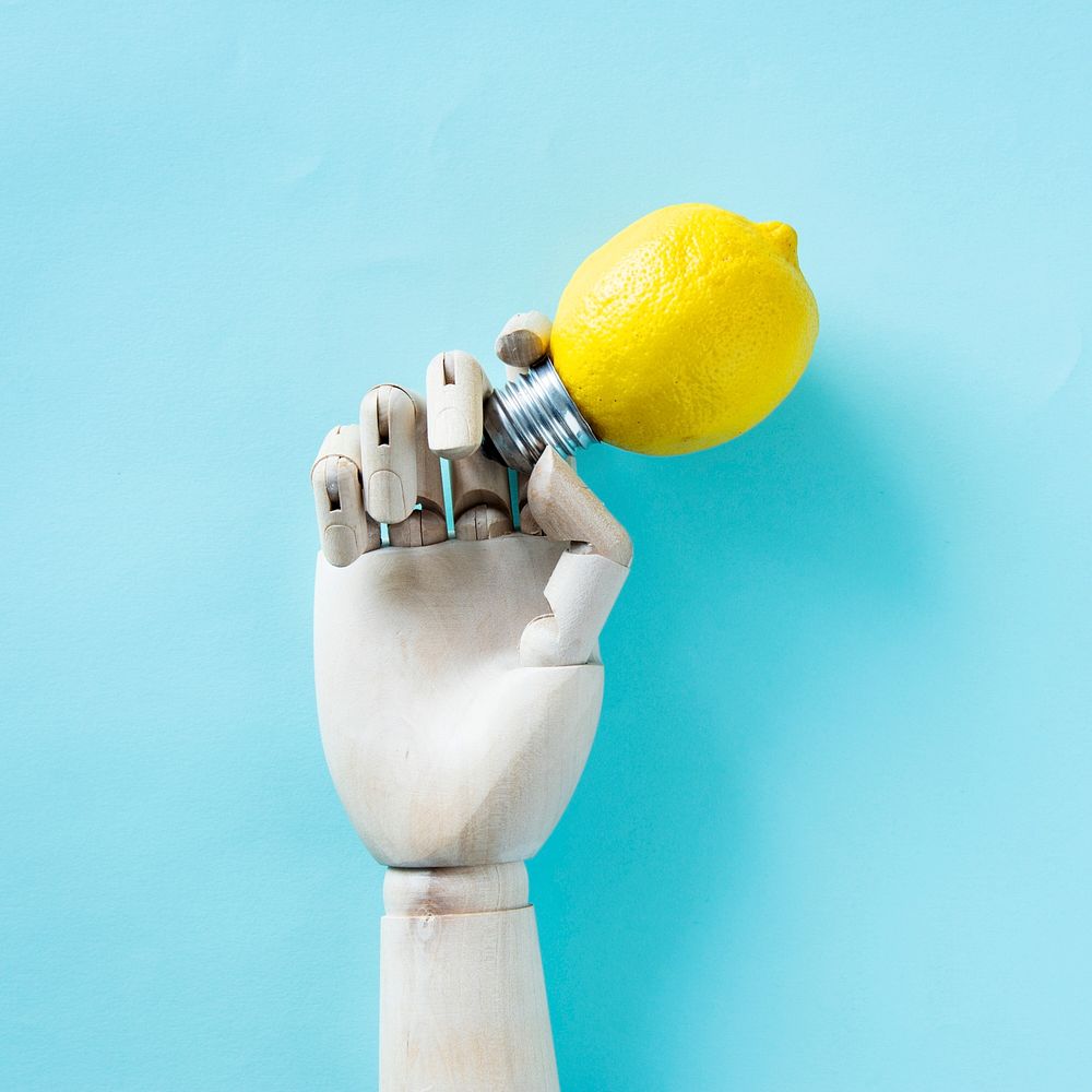 Robot hand holding a lemon bulb