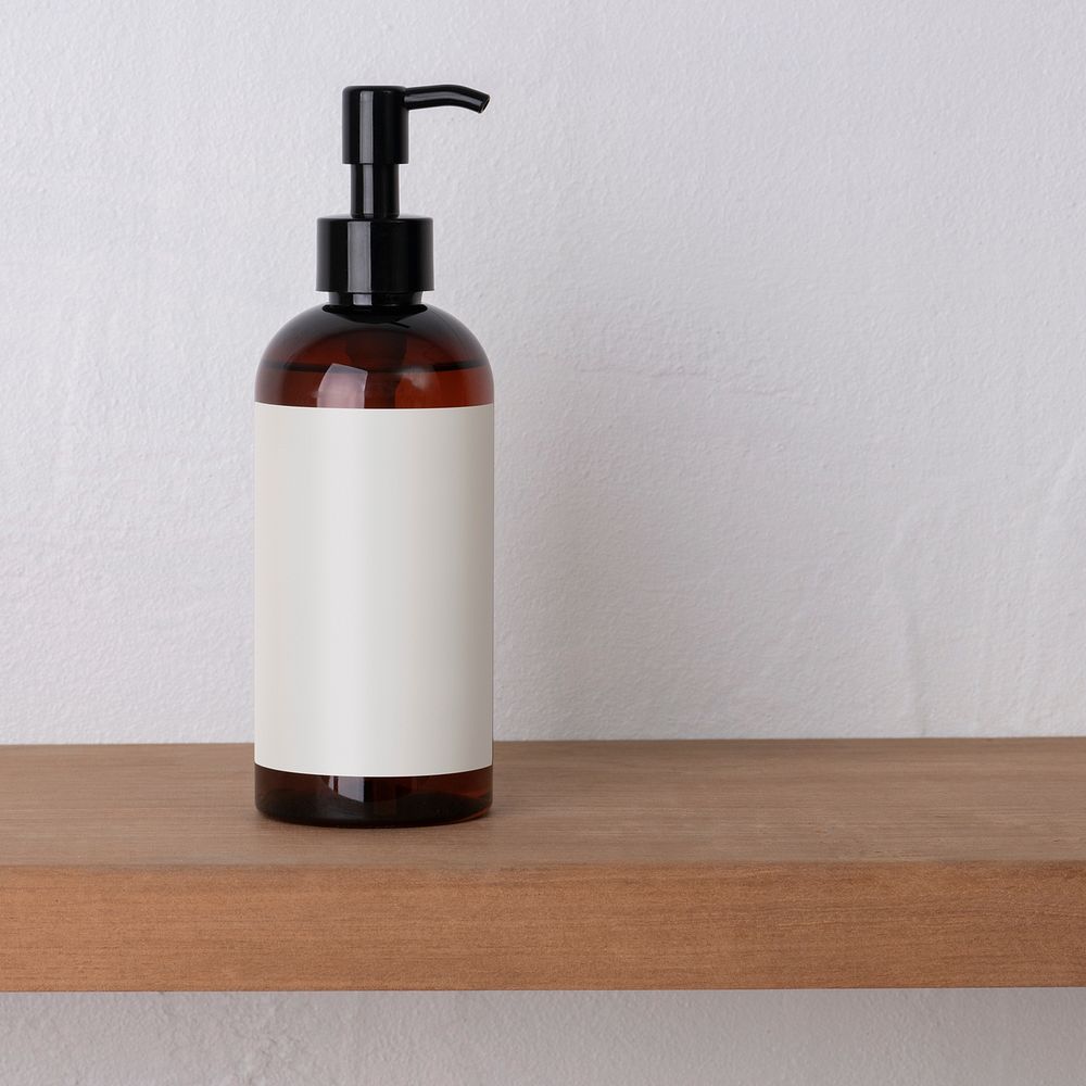 Brown dispenser bottle, blank white label, skincare product packaging, wooden shelf