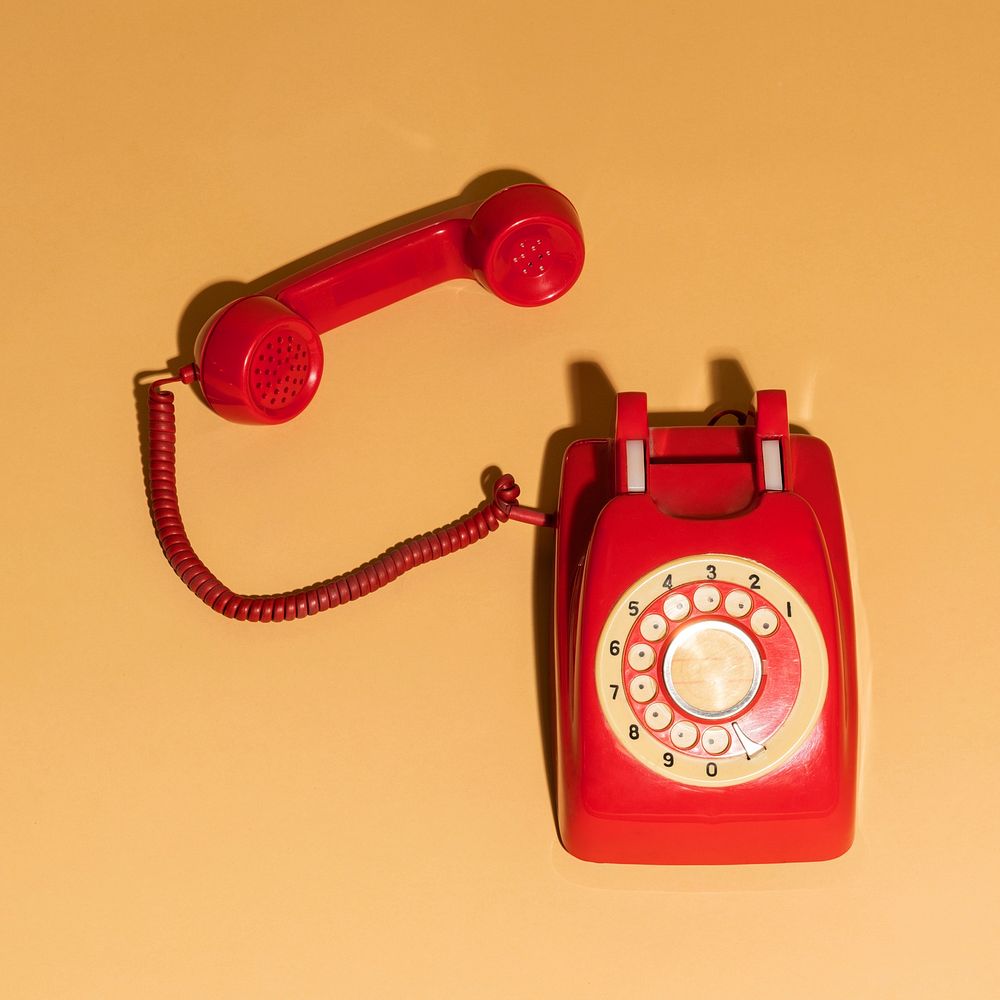 Red retro phone on a beige background