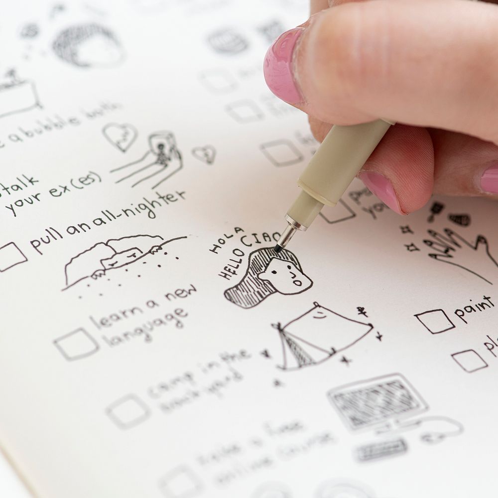 Girl doodling and making a checklist in a notebook