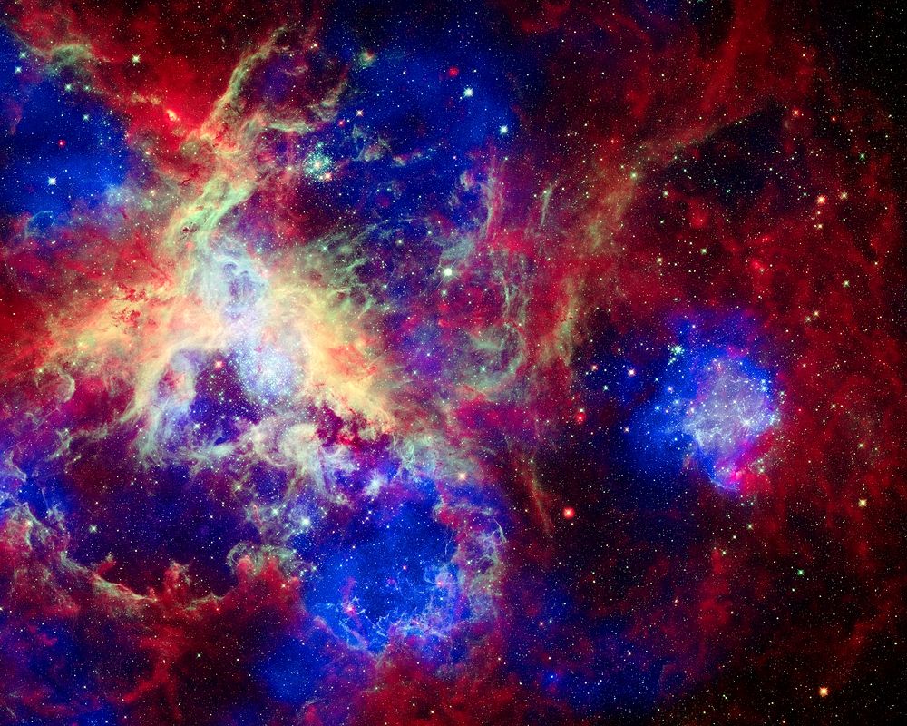 Composite of 30 Doradus, the Tarantula Nebula, contains data from Chandra (blue), Hubble (green), and Spitzer (red).…
