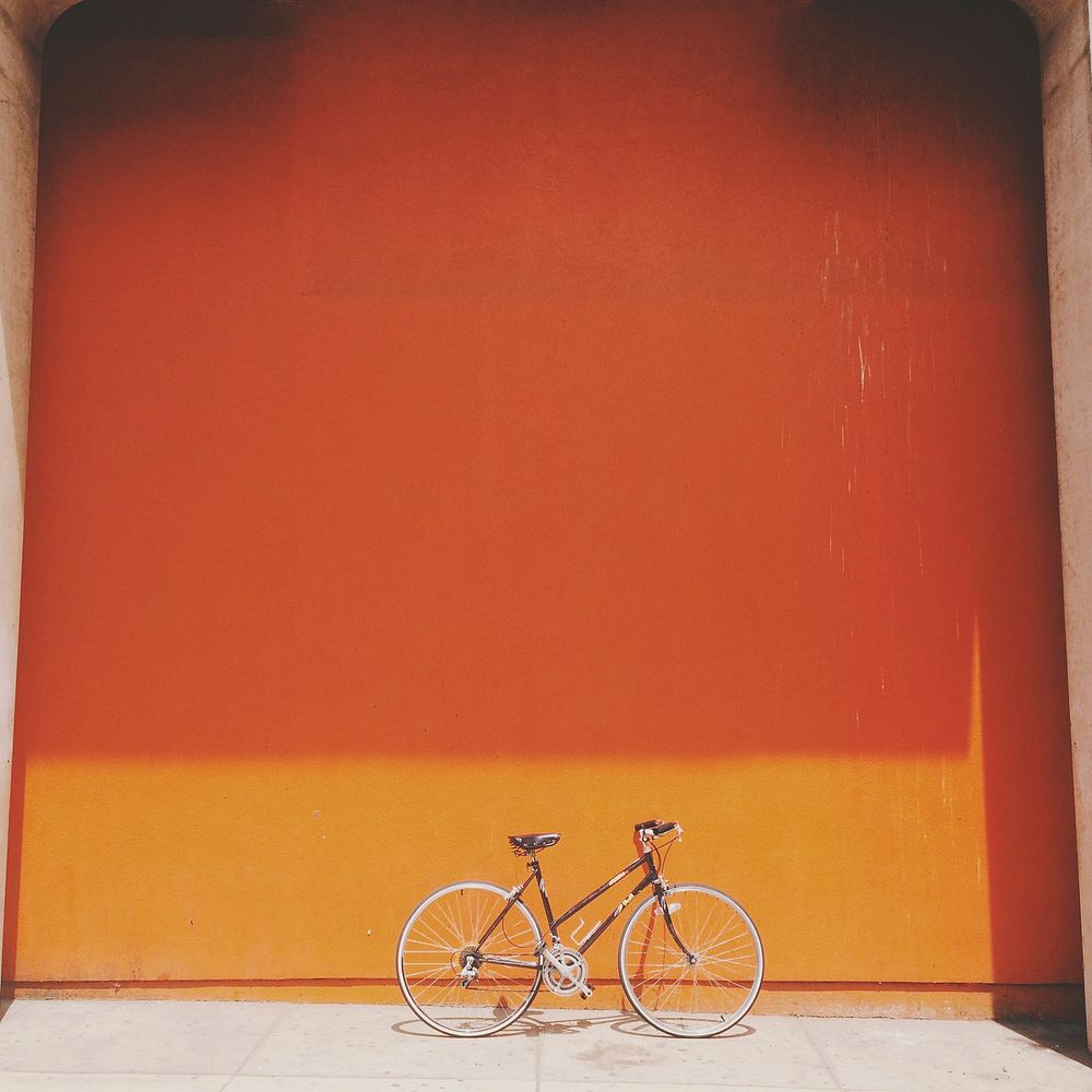 Free cycle with orange background image, public domain vehicle CC0 photo.