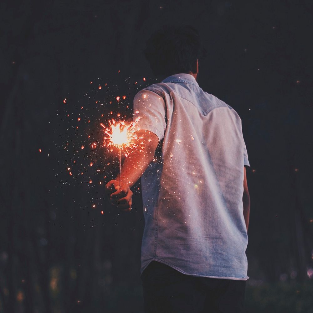 Person holding sparklers. Free public domain CC0 photo.