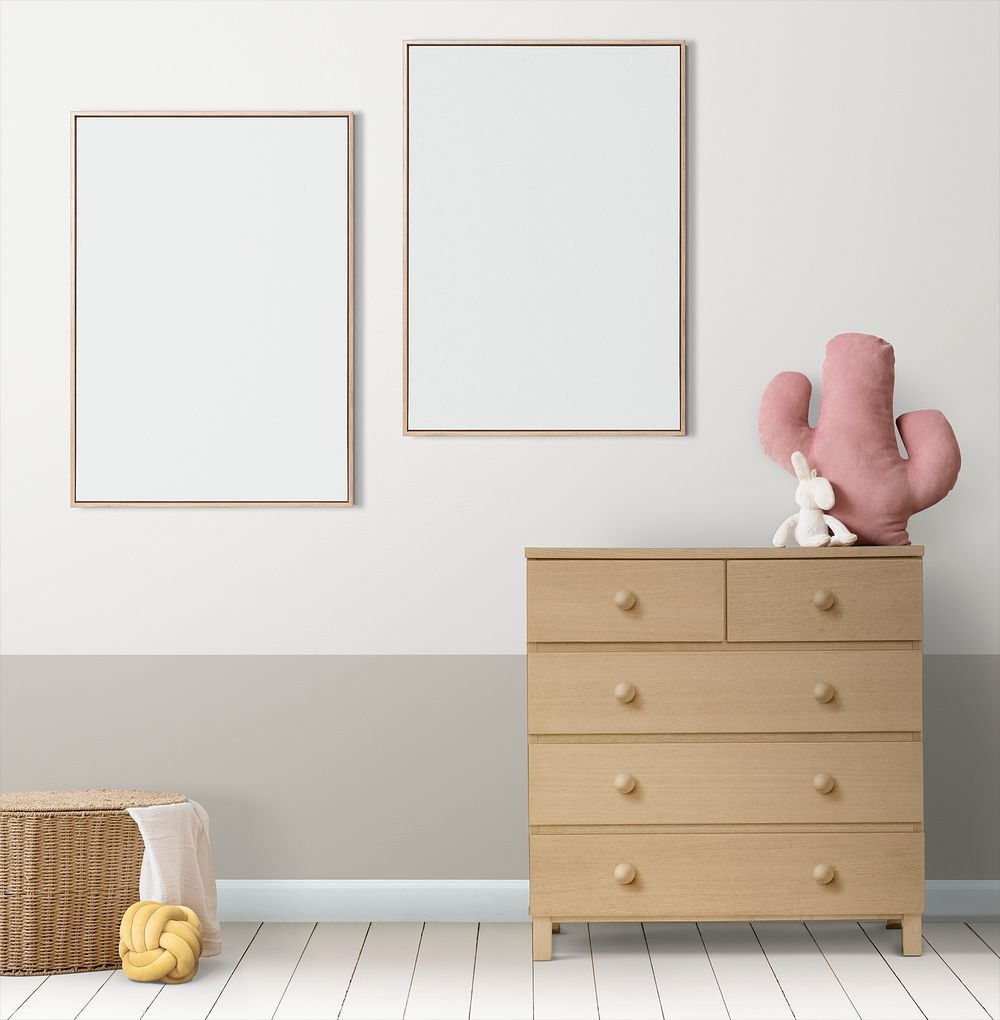 Blank picture frames hanging above a crib in a minimal nursery room