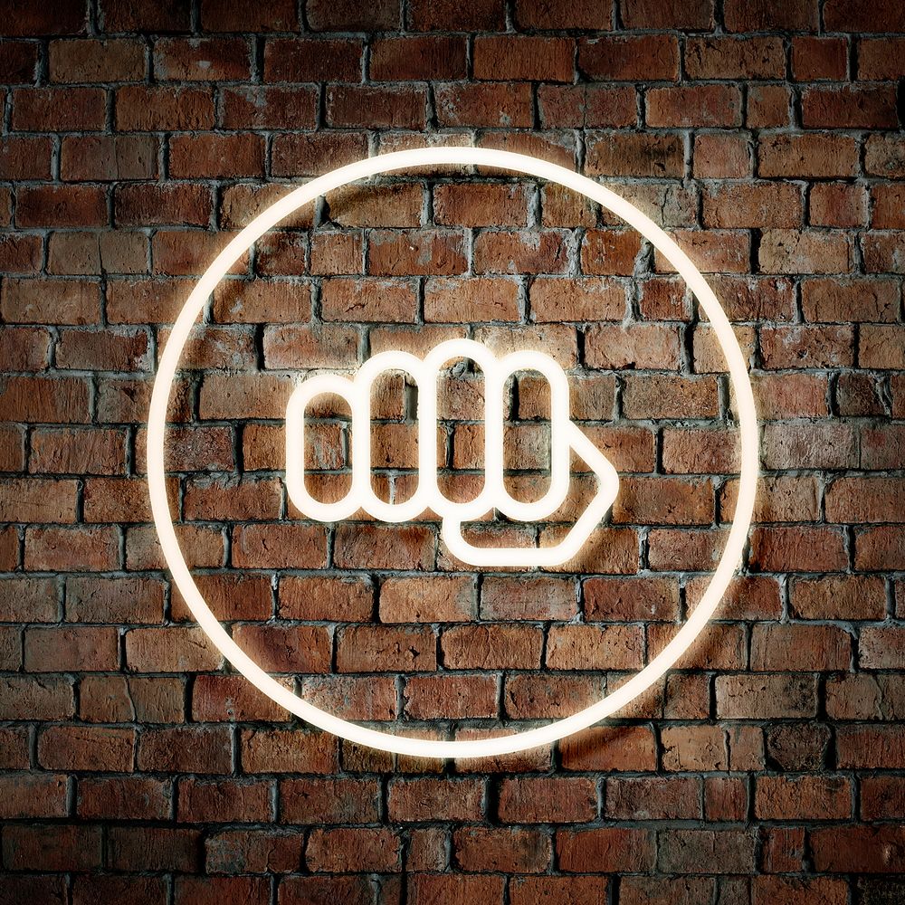 Neon fist in a round frame on a brick wall