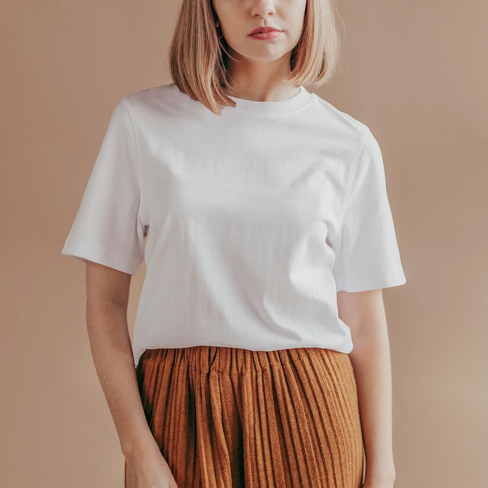 Confident blond woman in a white tee and orange pleated pants