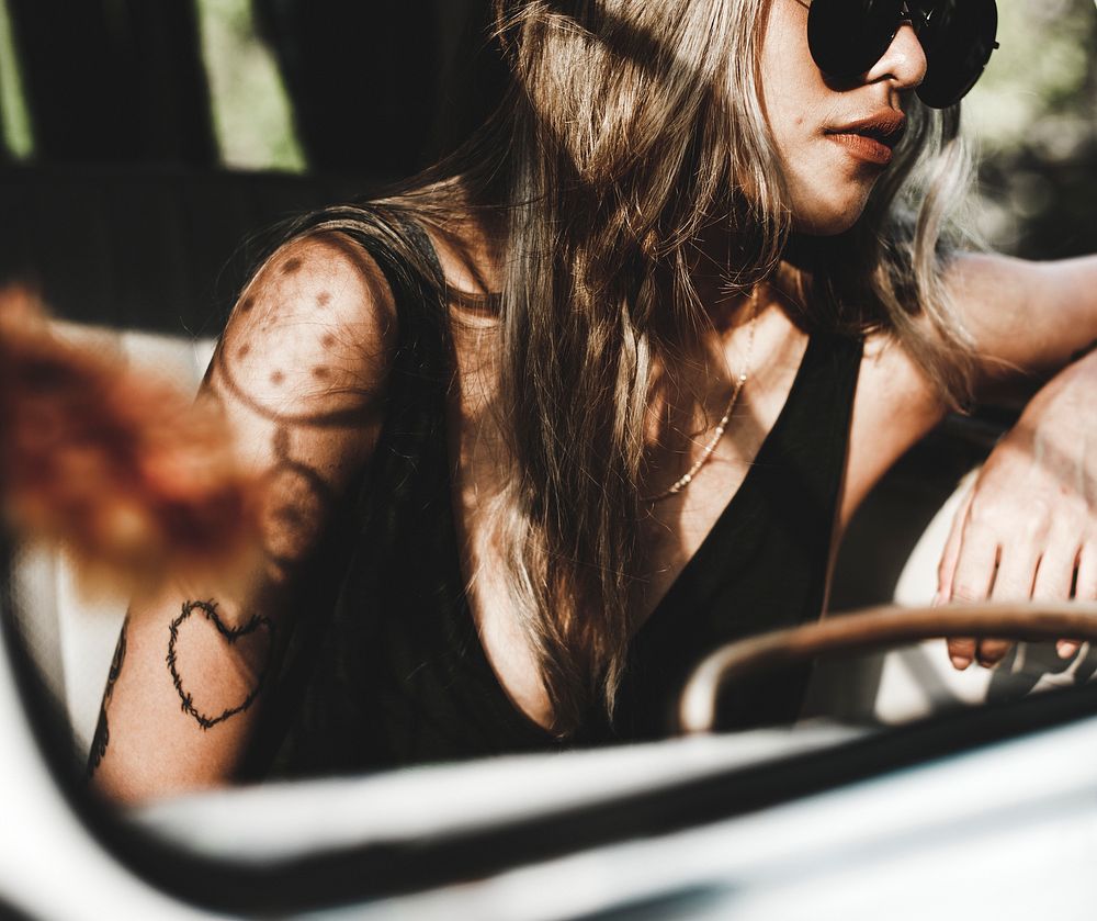 Tattooed Asian woman sitting in a car