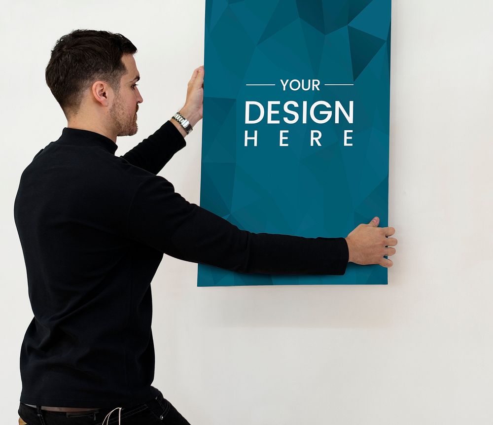 Man hanging a poster mockup on the wall