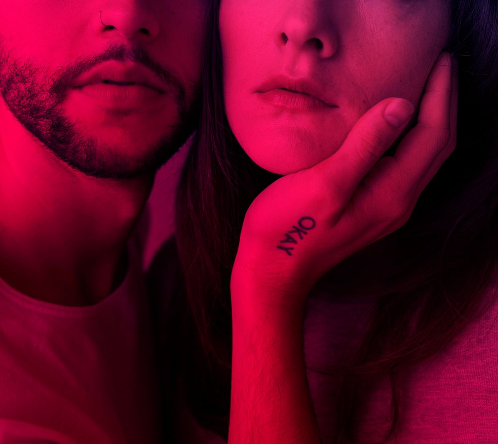 Man touching woman face with pink filter effect