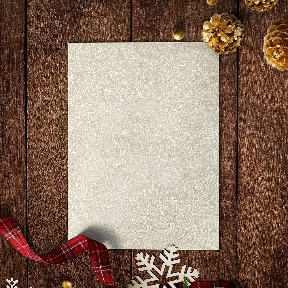 Gold paper mockup with Christmas decorations on wooden background