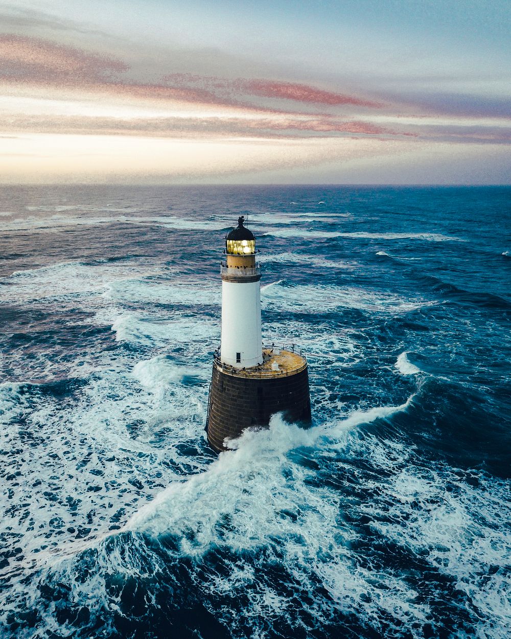 Waves hitting a lighthouse in Scotland