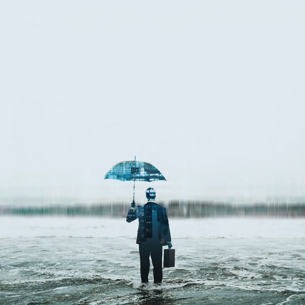 Businessman wearing suit with umbrella standing in sea