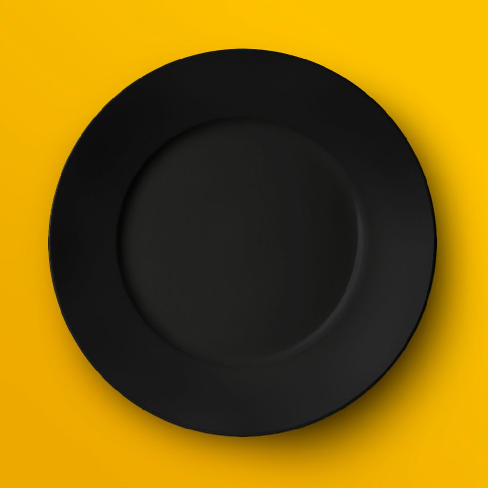 Black porcelain plate on yellow background