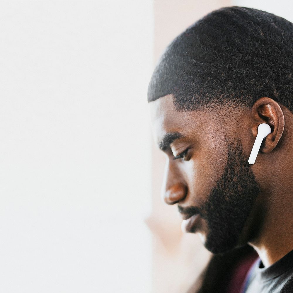 African American man listening to music on wireless earphones