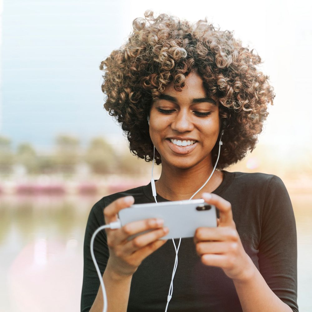 Woman holding smartphone psd remixed media with nature view