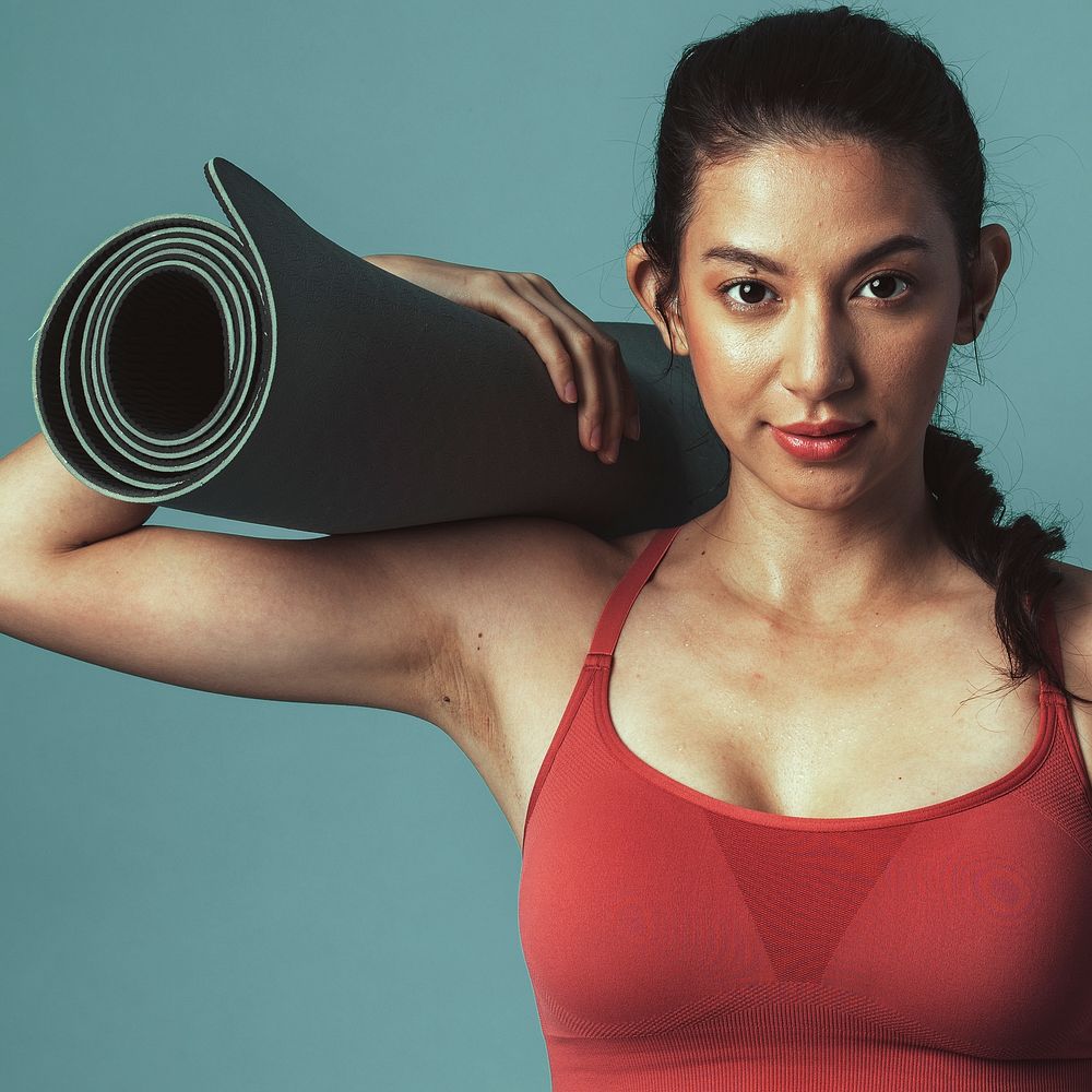 Healthy woman with a yoga mat 