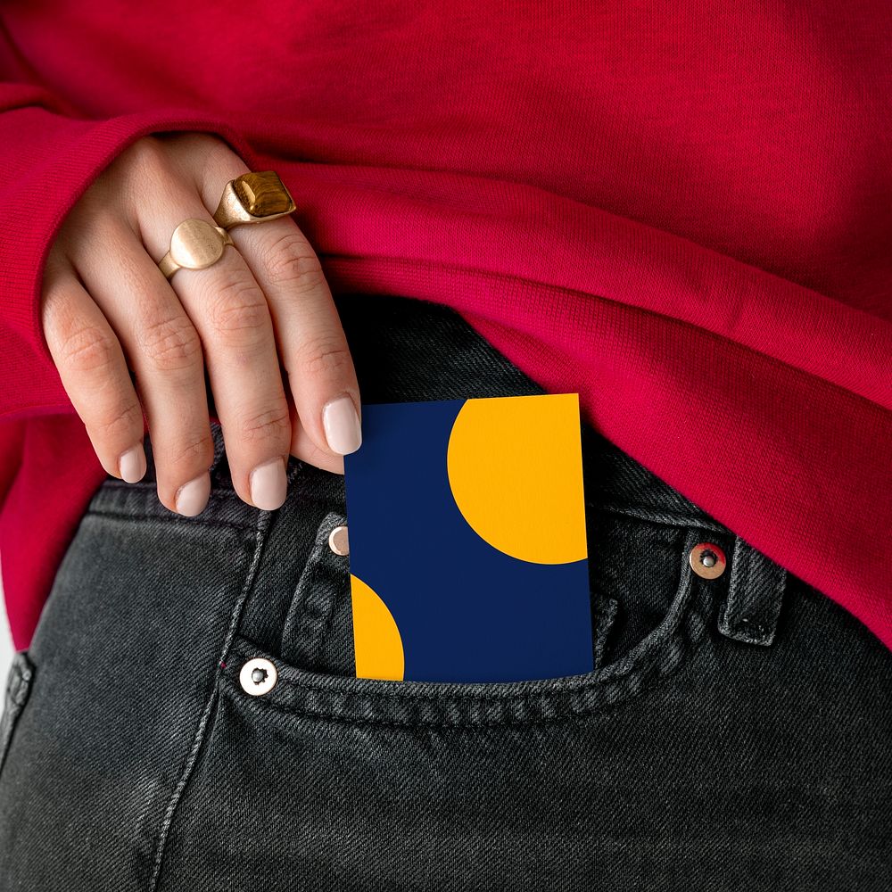 Woman keeping a card in a pocket of her jeans