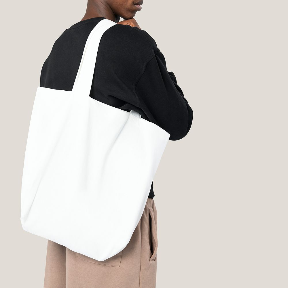 Man carrying white tote bag studio shoot