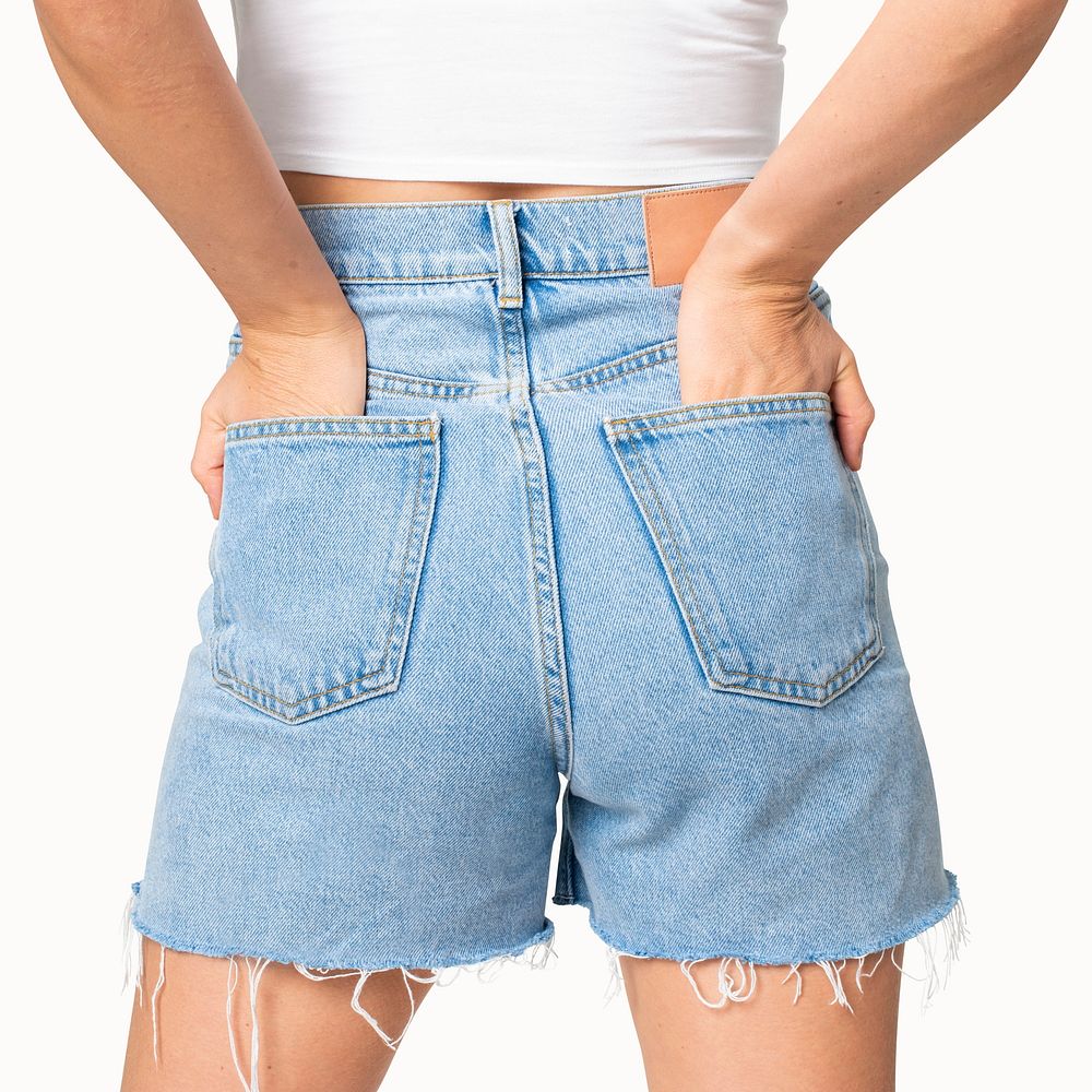Woman in blue denim shorts with hand tucked in pocket rear view