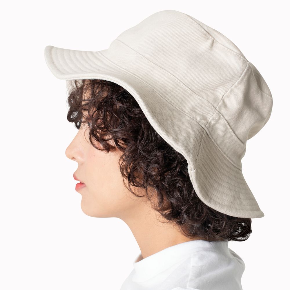 Beautiful woman in white bucket hat fashion studio shoot