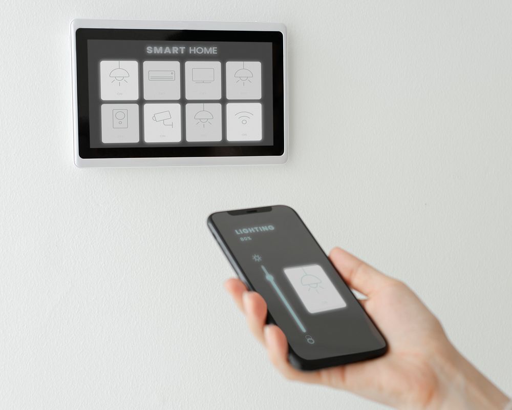 Woman using smart phone for home automation panel monitor