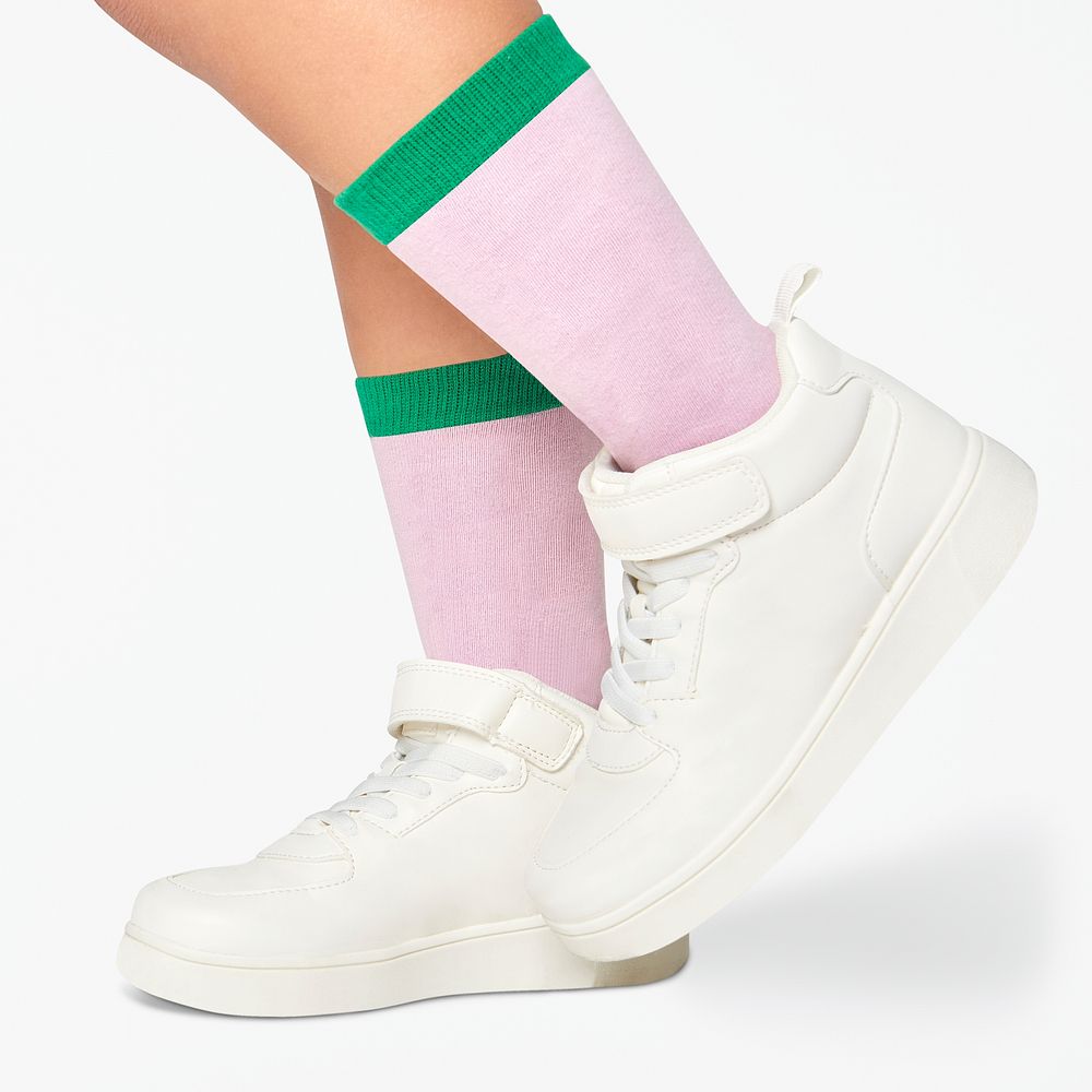 Kid wearing pink with green stripe socks white sneakers studio shot