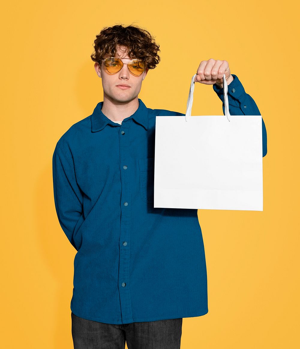 Serious man holding shopping bag