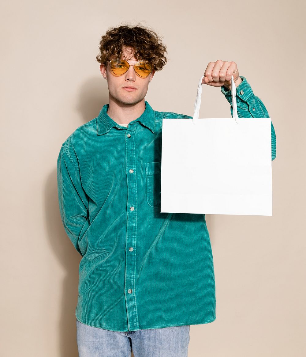 Unhappy man holding shopping bag