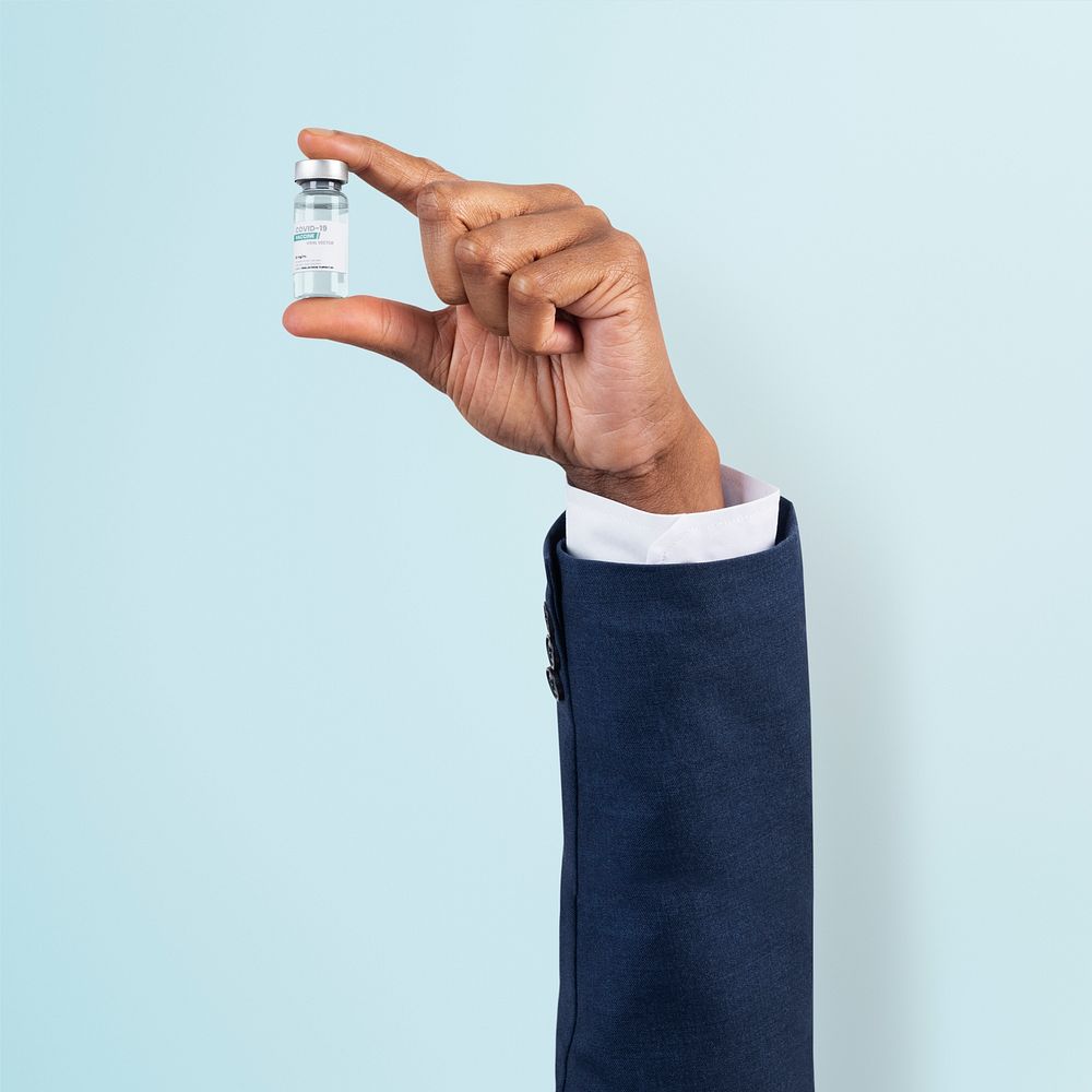 Covid-19 vaccine mockup psd held by a businessman’s hand