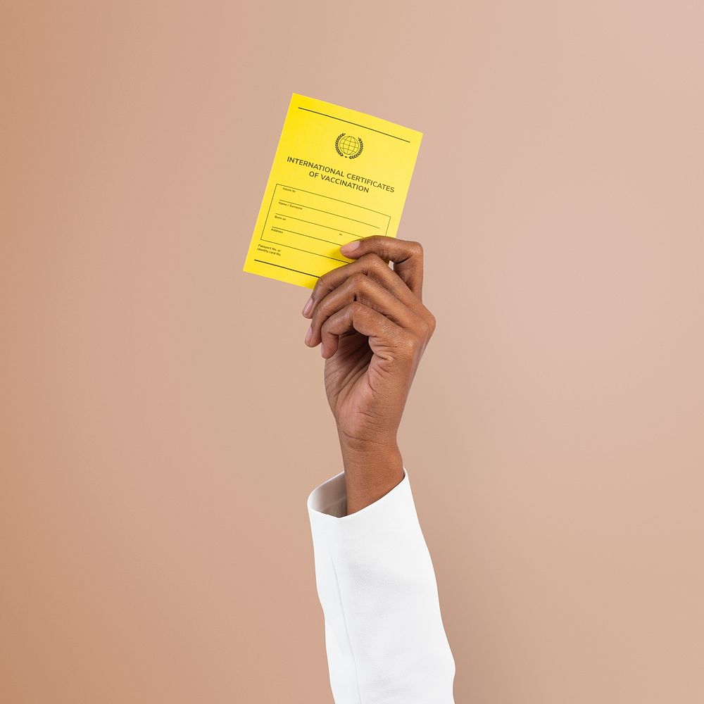 Covid-19 vaccine certificate mockup psd held by a businessman&rsquo;s hand